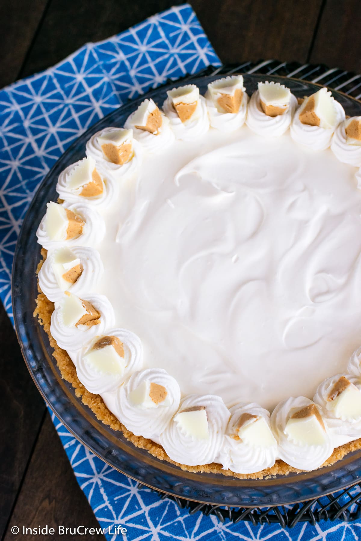 A close up of the top of pie topped with Cool Whip and candy.