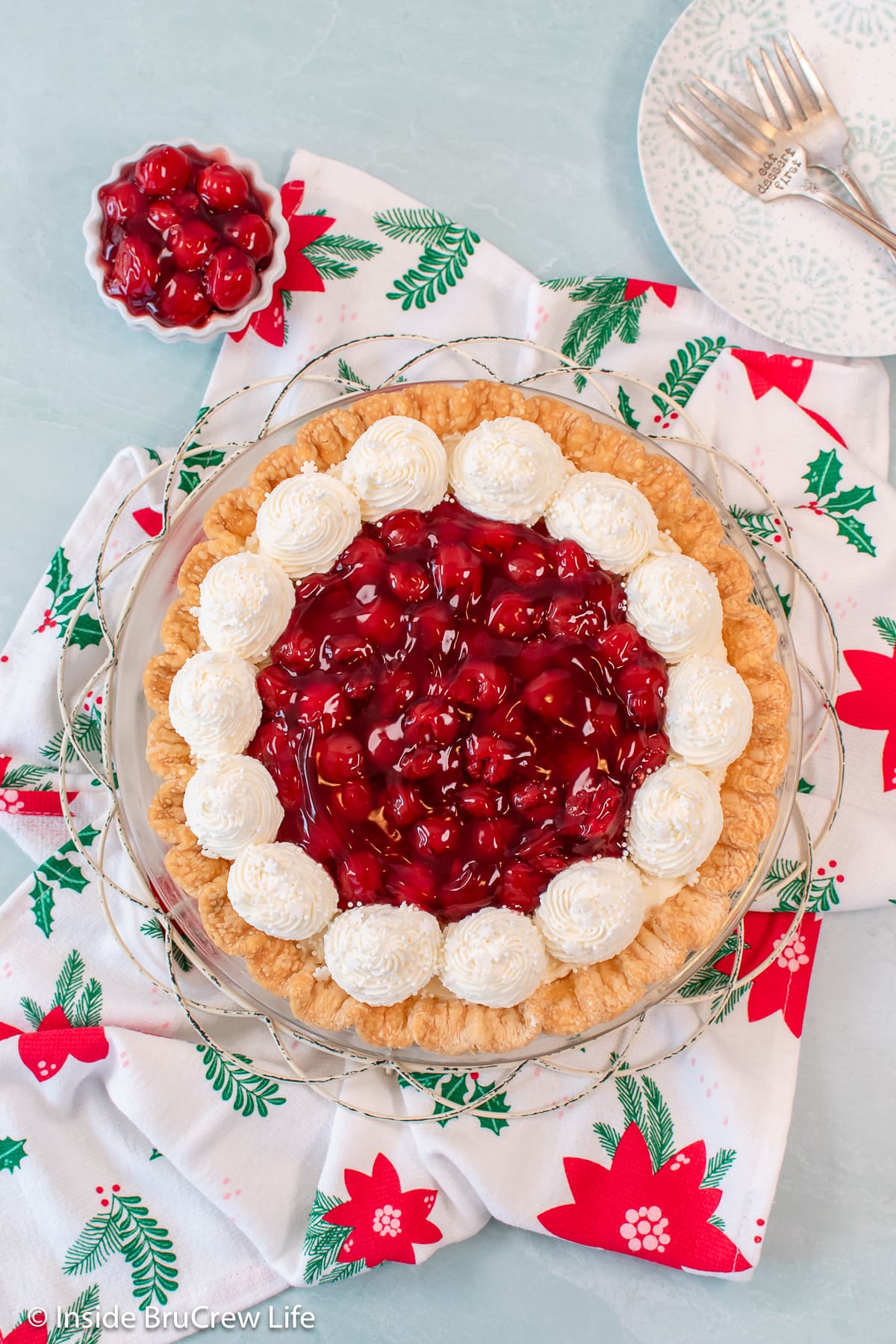 On overhead picture of a decorated cherry cheese pie.