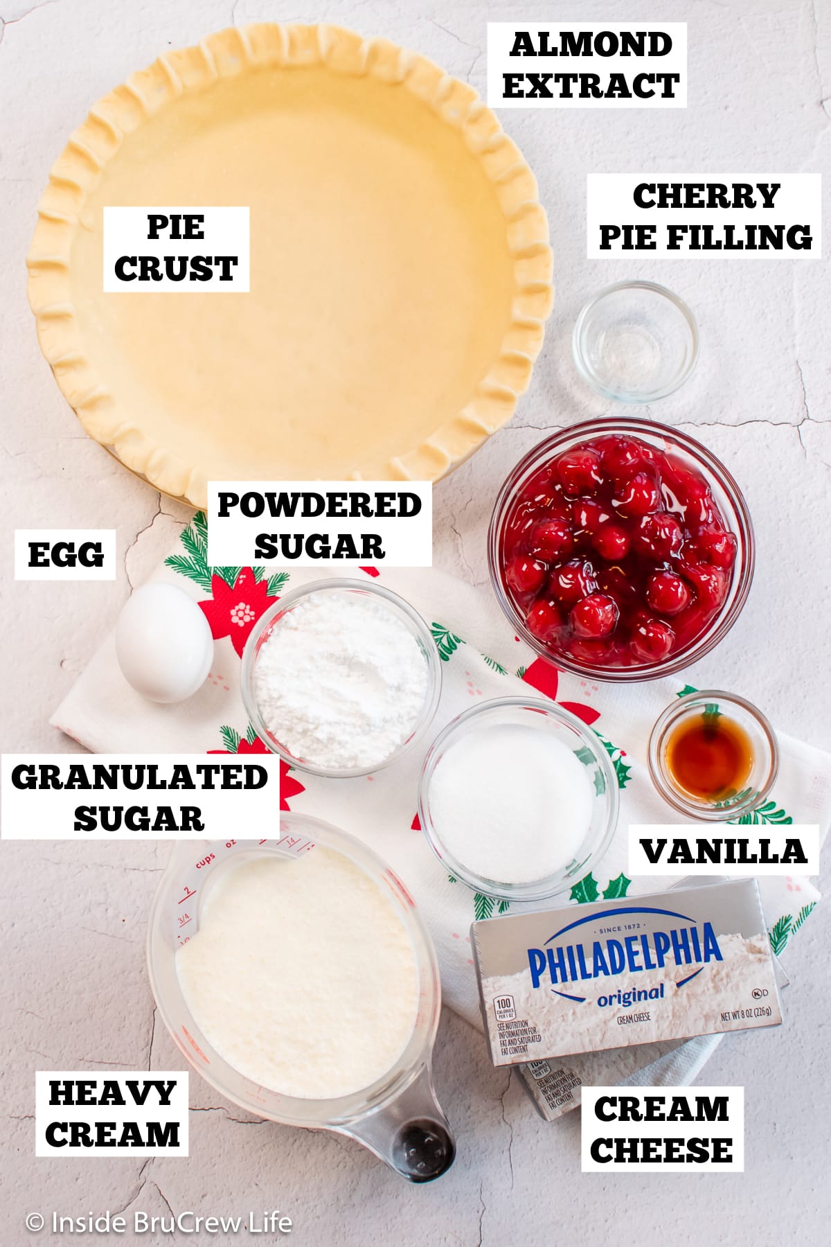 A white board with bowls of ingredients needed to make a pie with cheesecake.