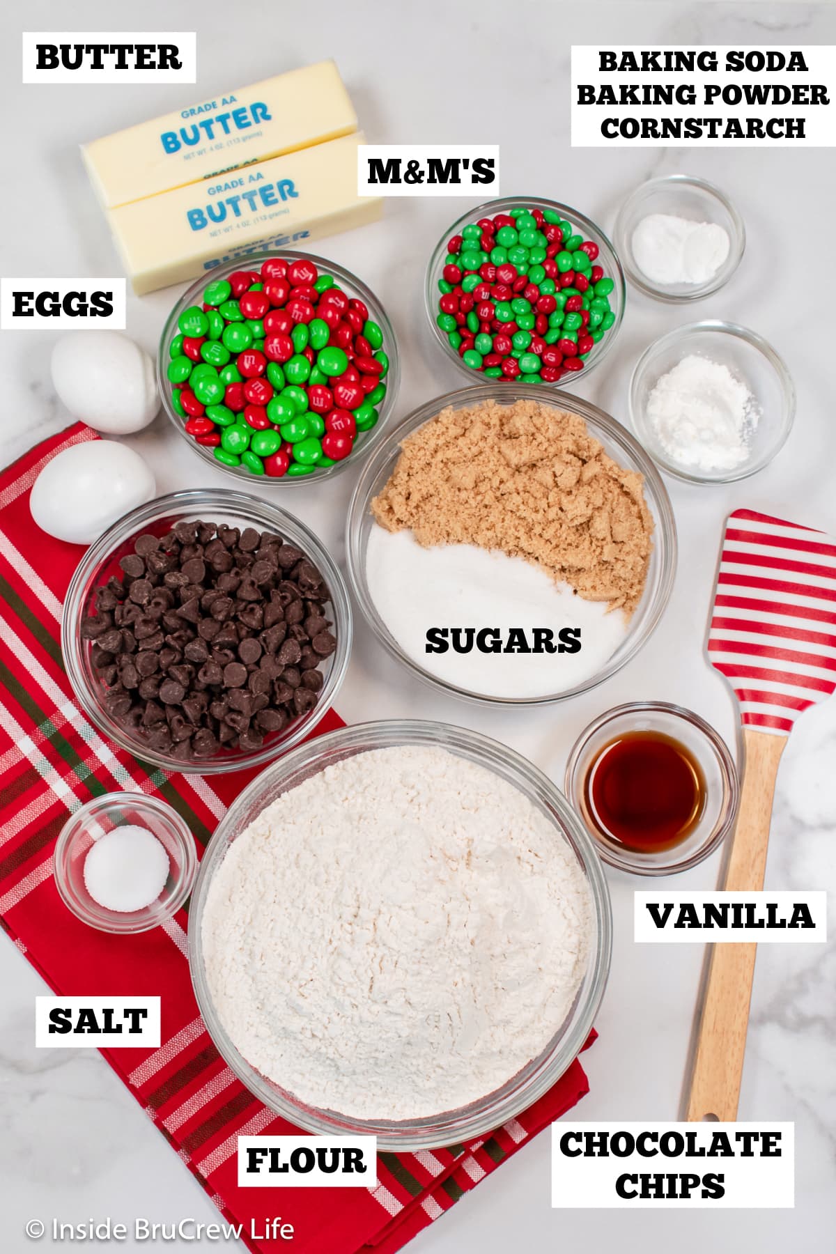 A white board with bowls of ingredients needed to make holiday cookies.