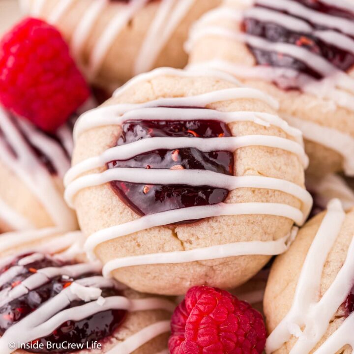 A jam thumbprint cookie drizzled with glaze.