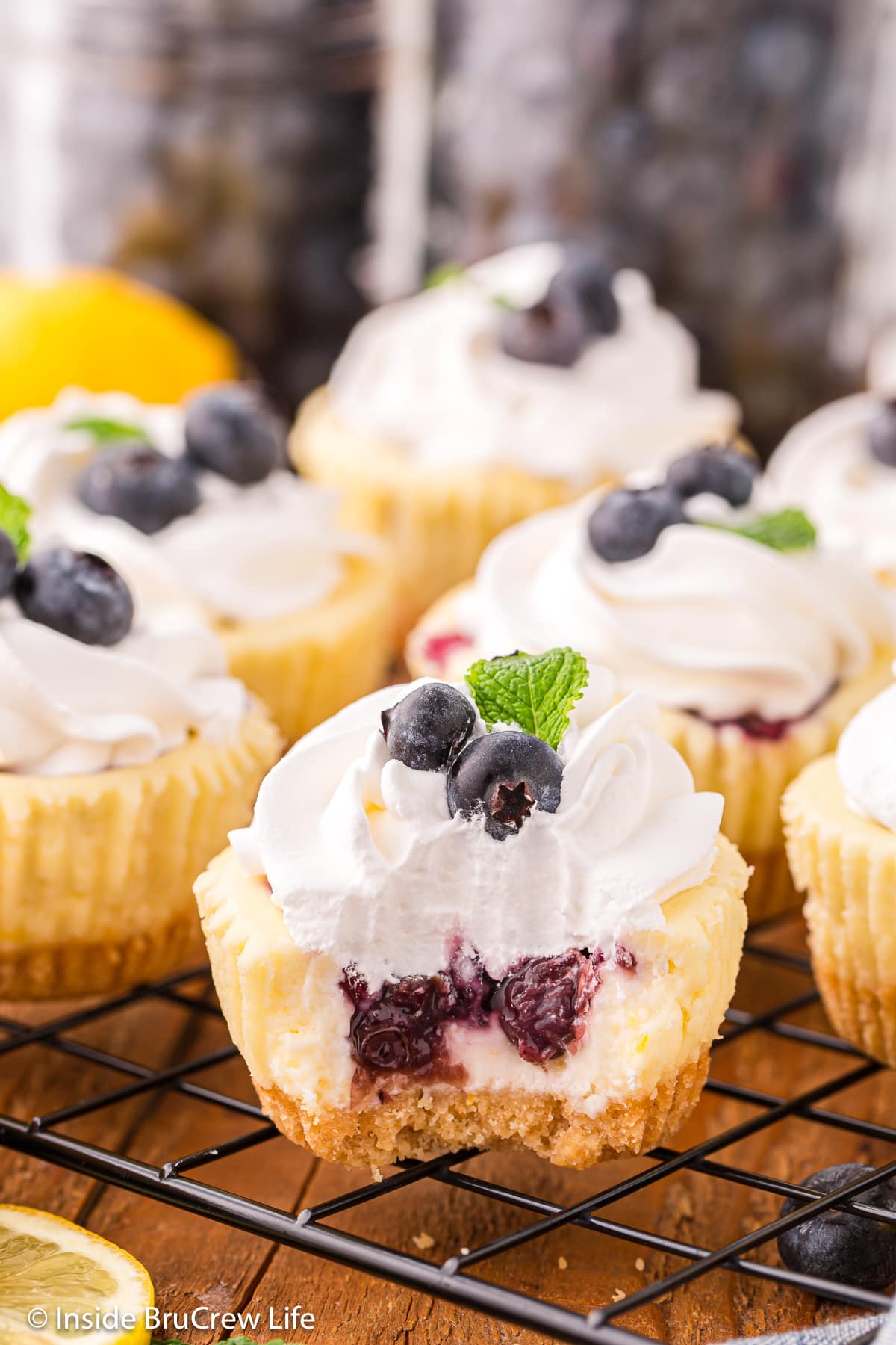 Mini lemon blueberry cheesecakes with a bite out of one.