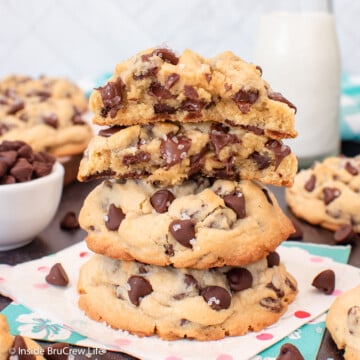 A big stack of thick cookies with one split open on top.