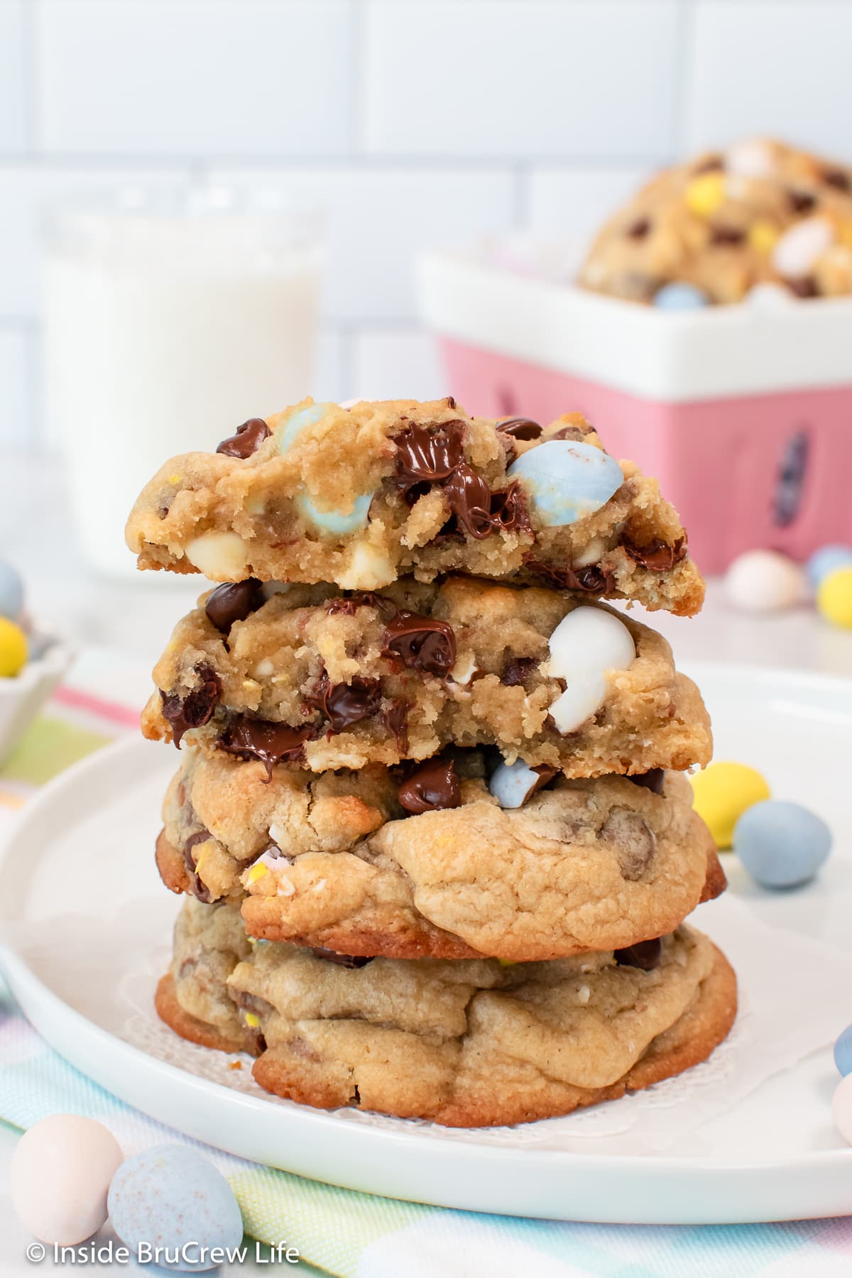 A stack of cookies showing the gooey chocolate insides of the top one.