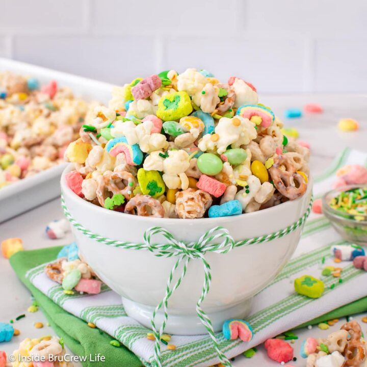 A white bowl filled with a st. patrick's day popcorn mix.