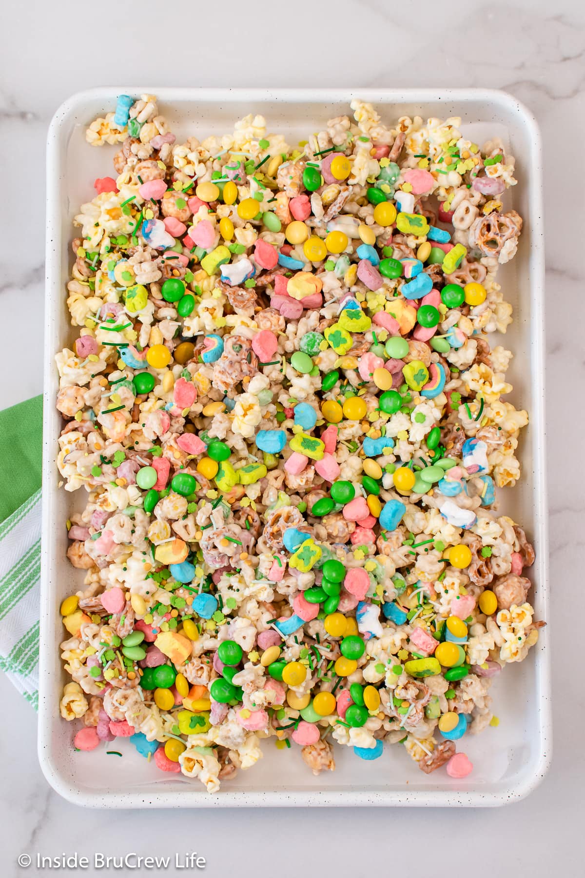 A white sheet pan filled with popcorn and marshmallows.