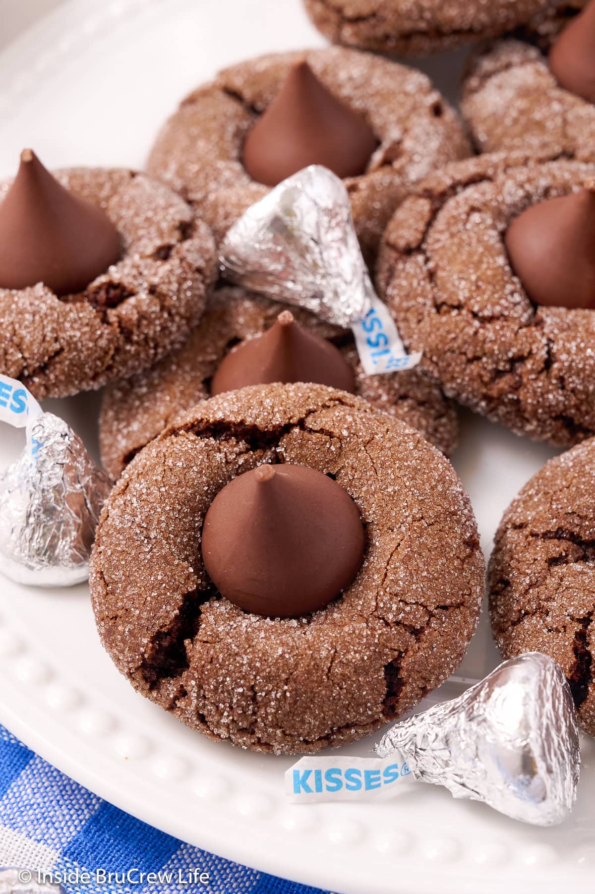 Chocolate cookies topped with Hershey kisses on a plate.