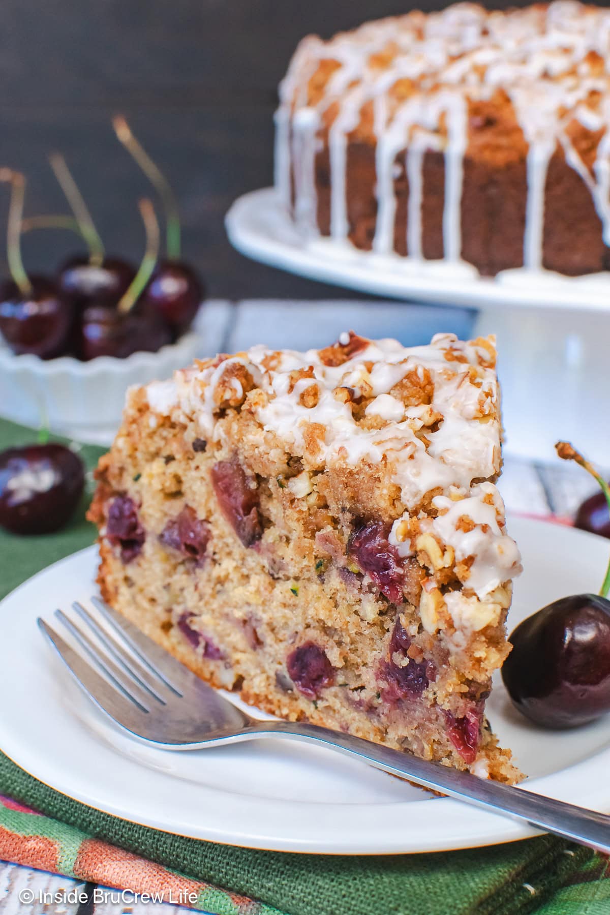 A slice of zucchini coffee cake with cherries in it.