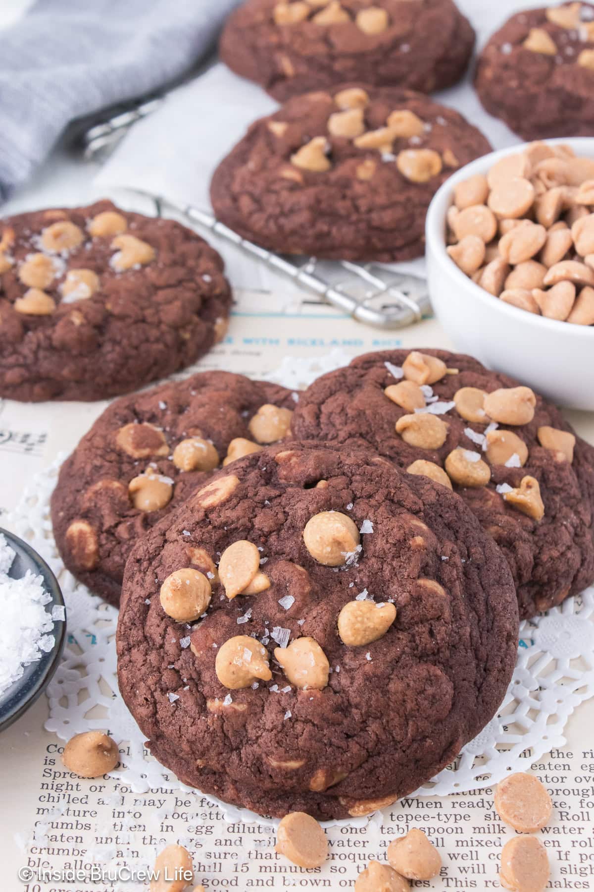 A pile of chocolate peanut butter chip cookies on white paper.