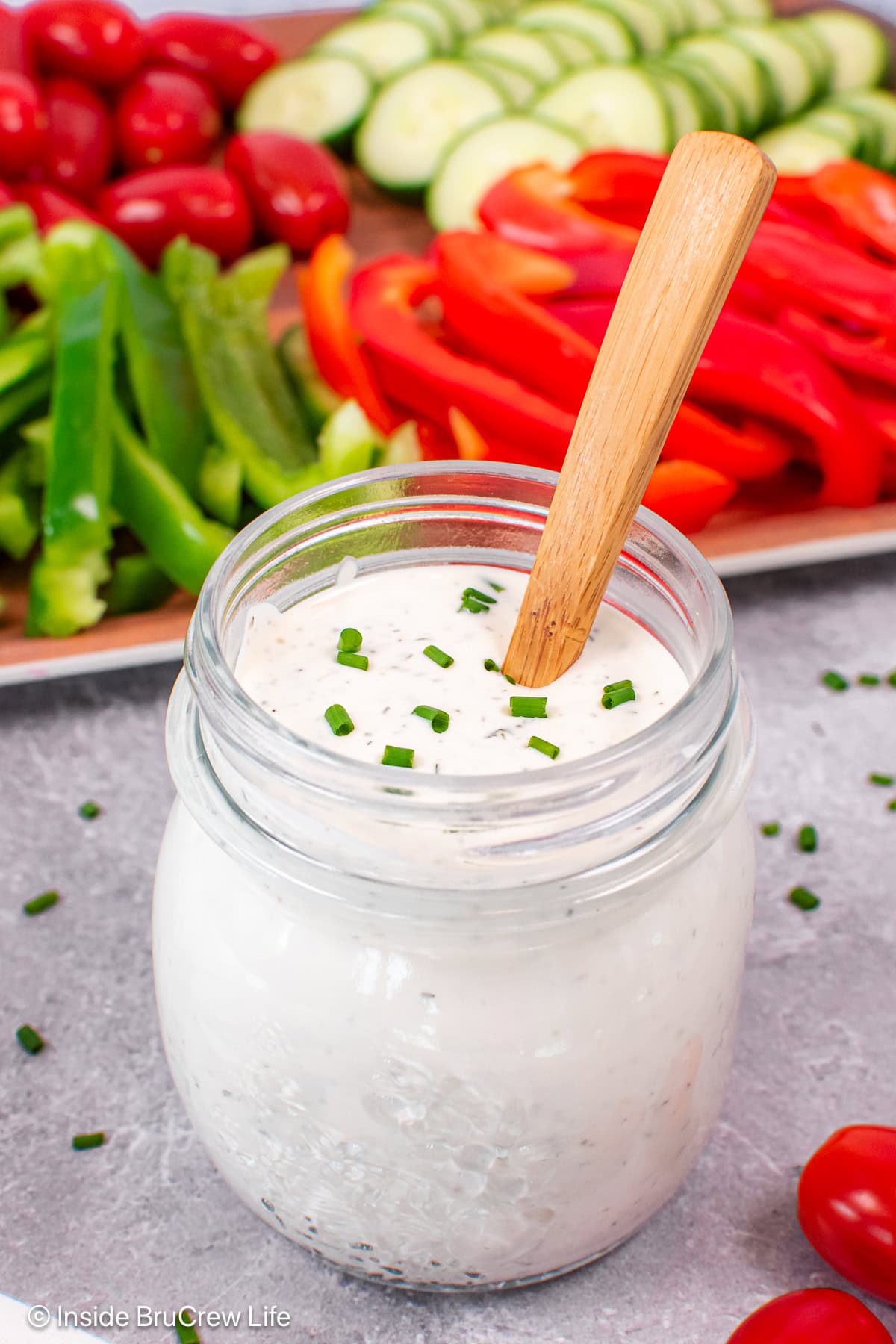A clear jar filled with homemade ranch dressing.