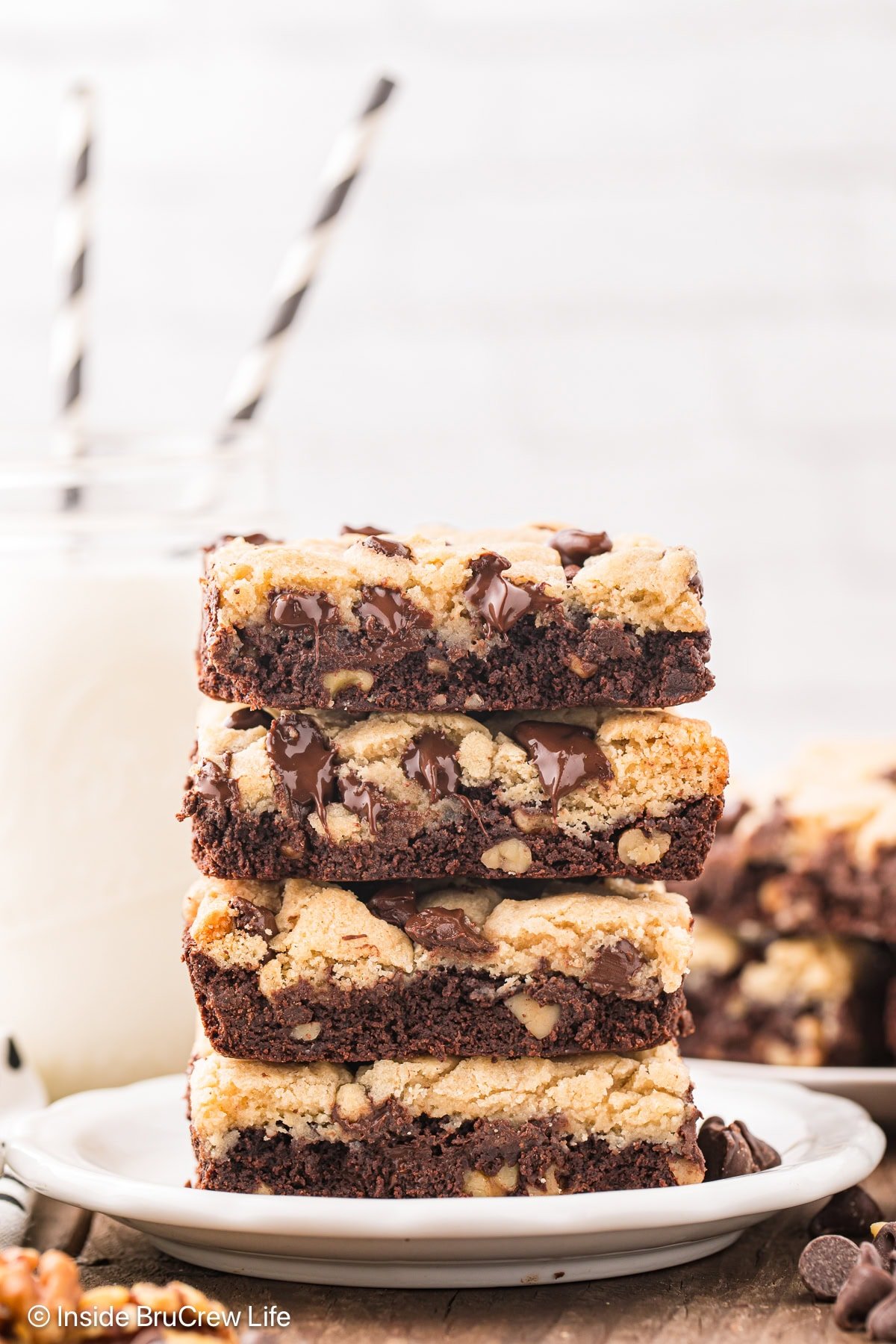 A stack of four brookie bars on a white plate.