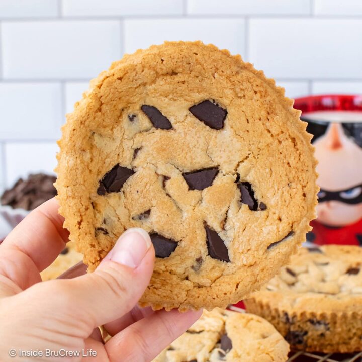 A large num num cookie being held in the air.