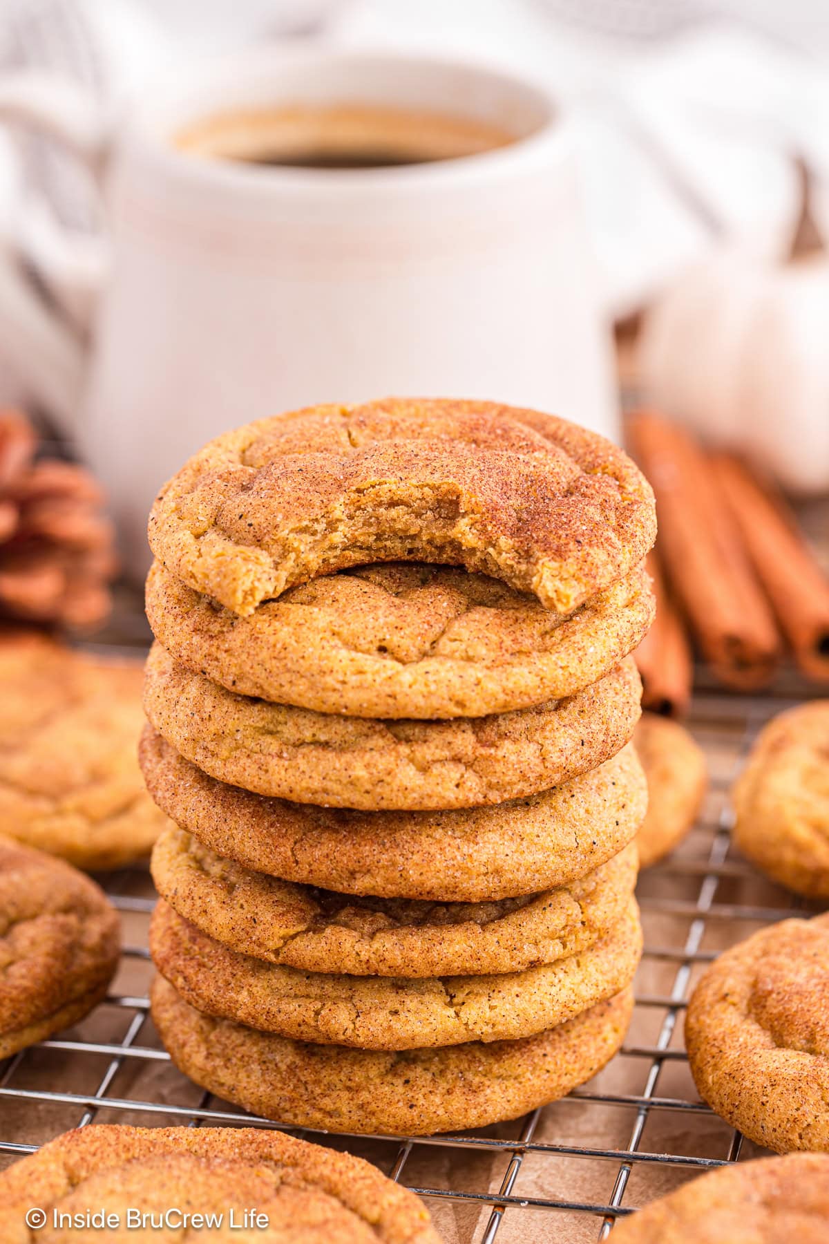 A stack of pumpkin snickerdoodles on a wire rack.