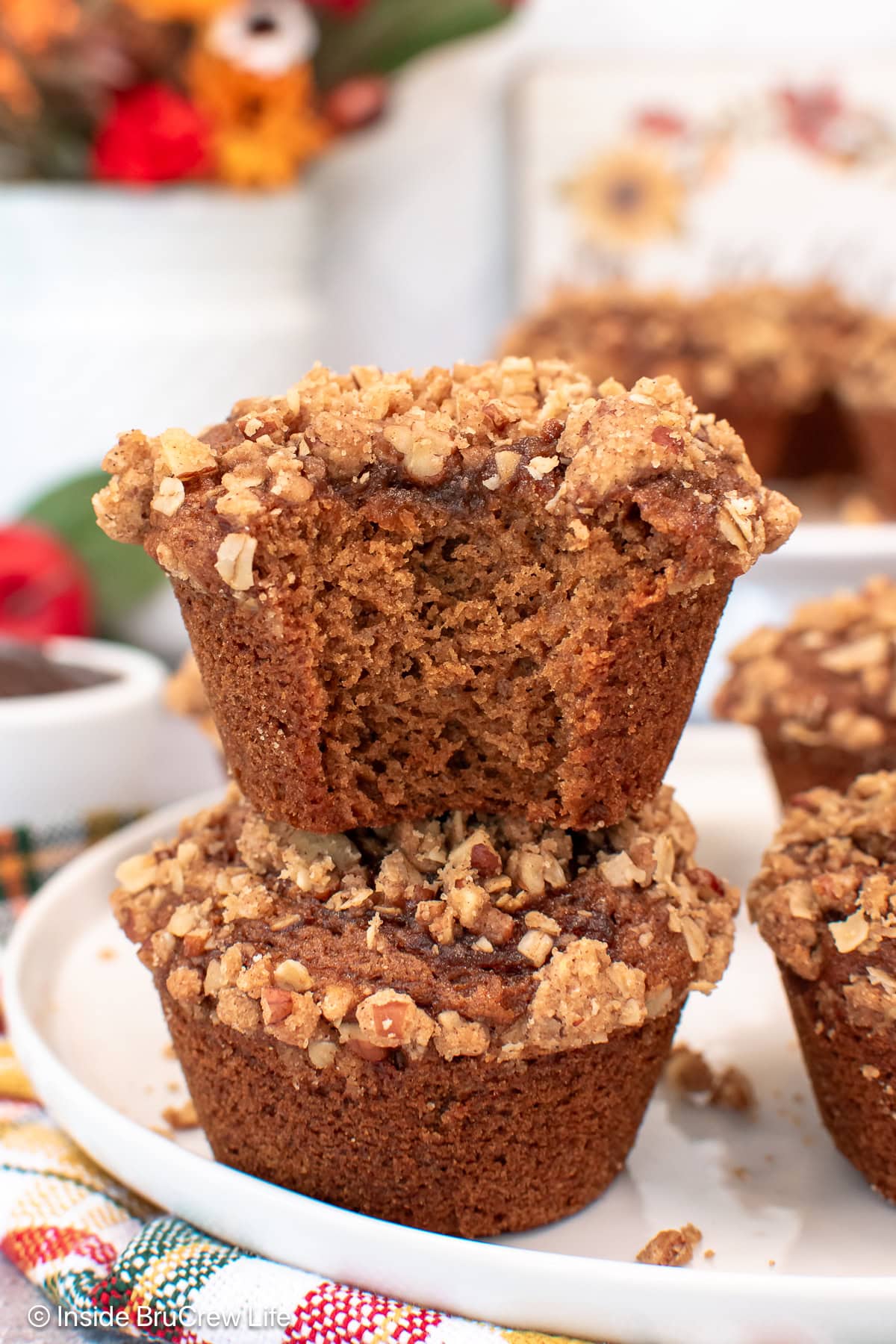 Two muffins stacked on top of each other with a bite out of the top one.