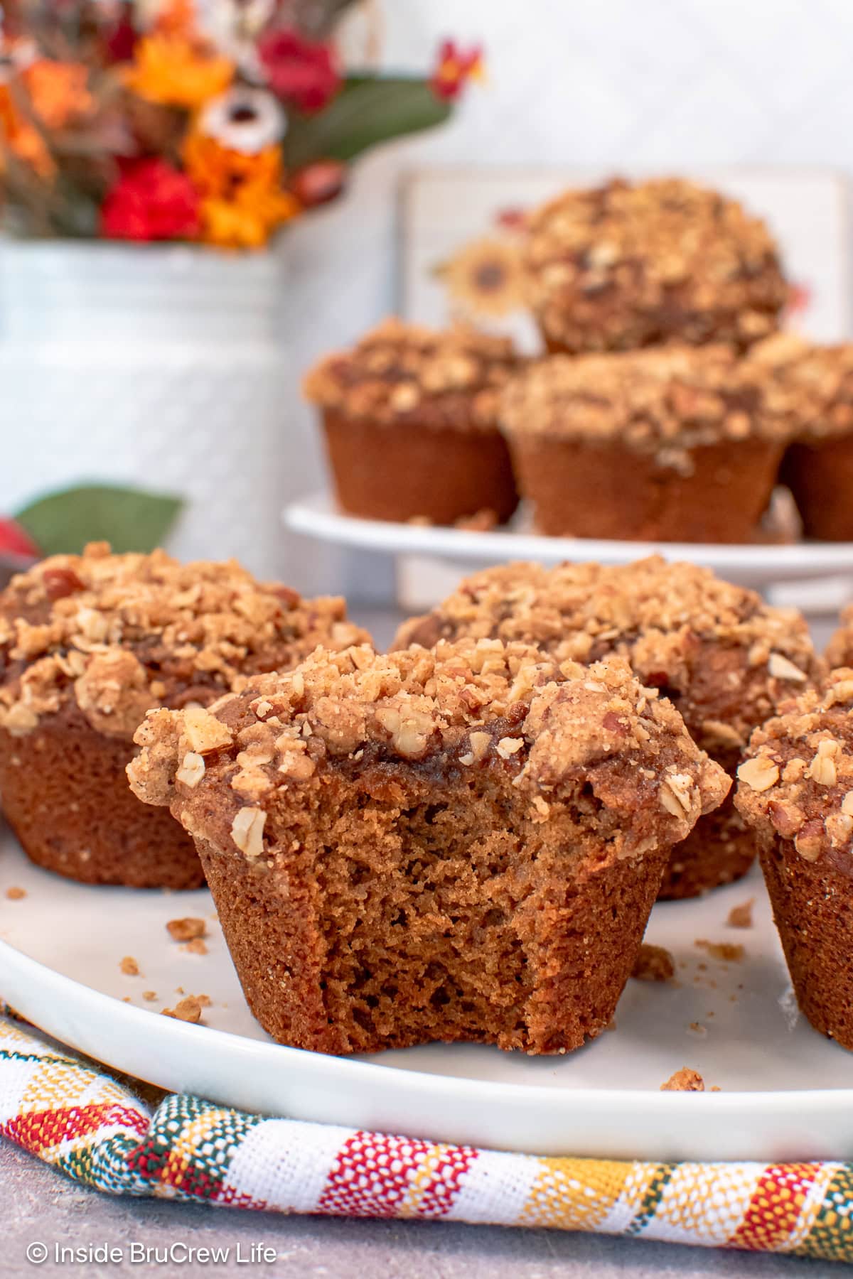 A white plate with streusel topped muffins on it.