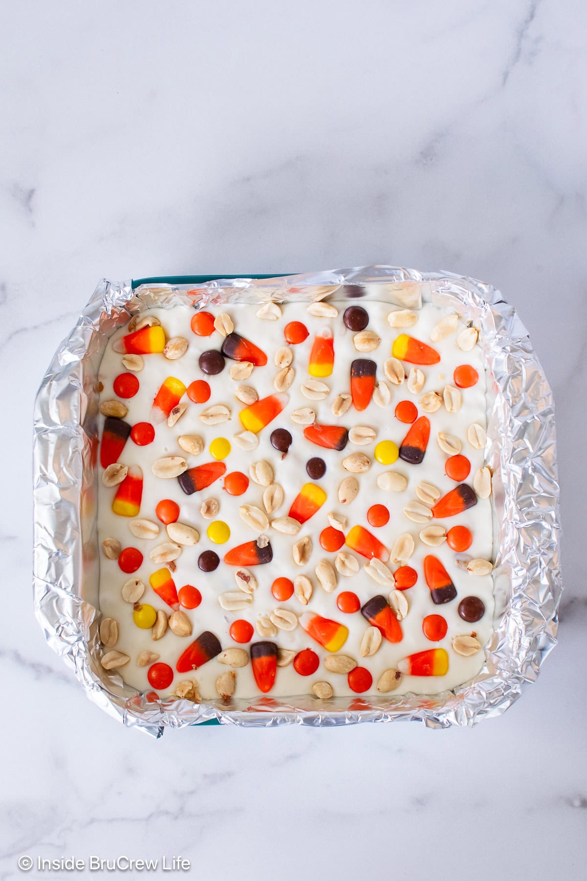 A pan of white chocolate fudge topped with a candy corn mix.