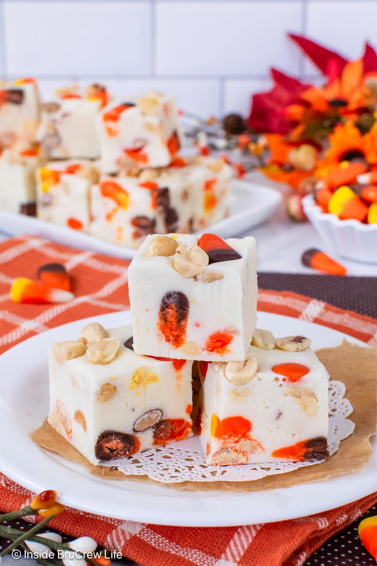 Three squares of fall fudge on a white plate.