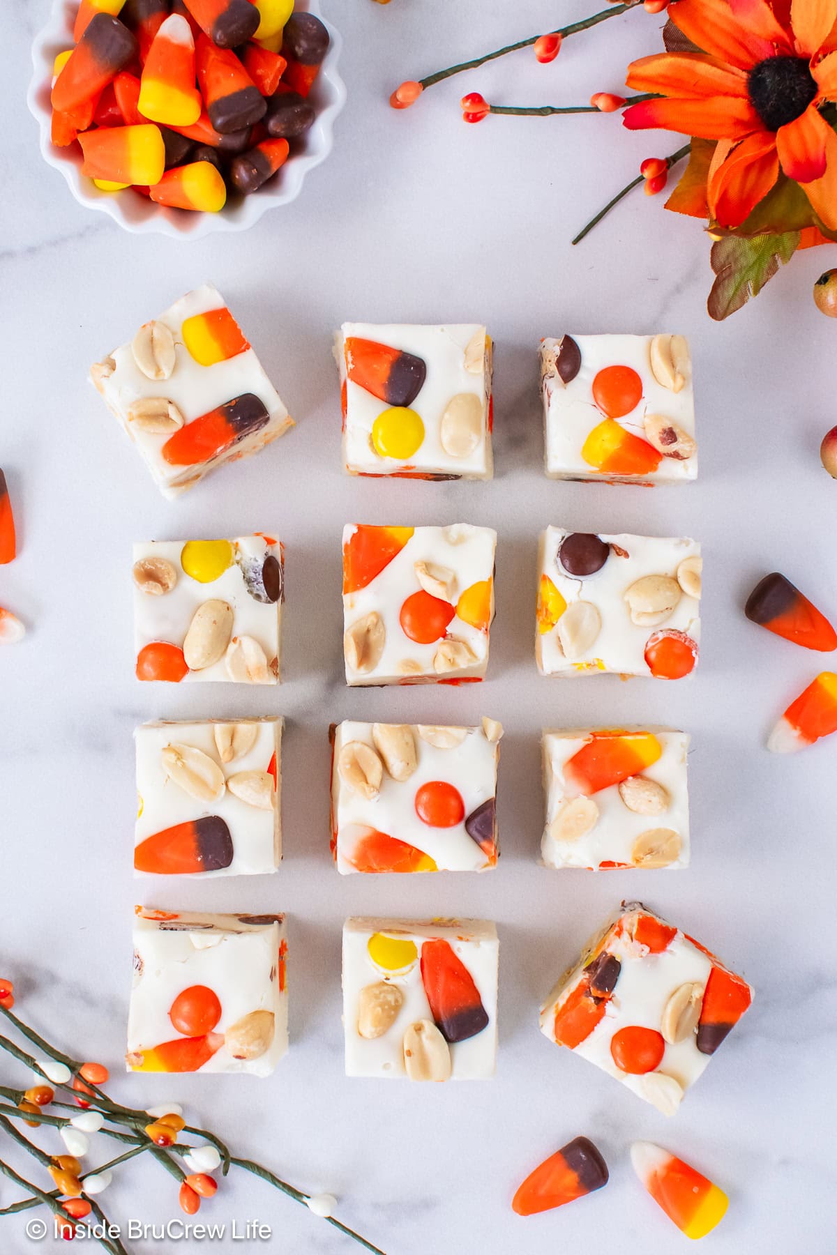 Squares of candy corn fudge on a white tray.