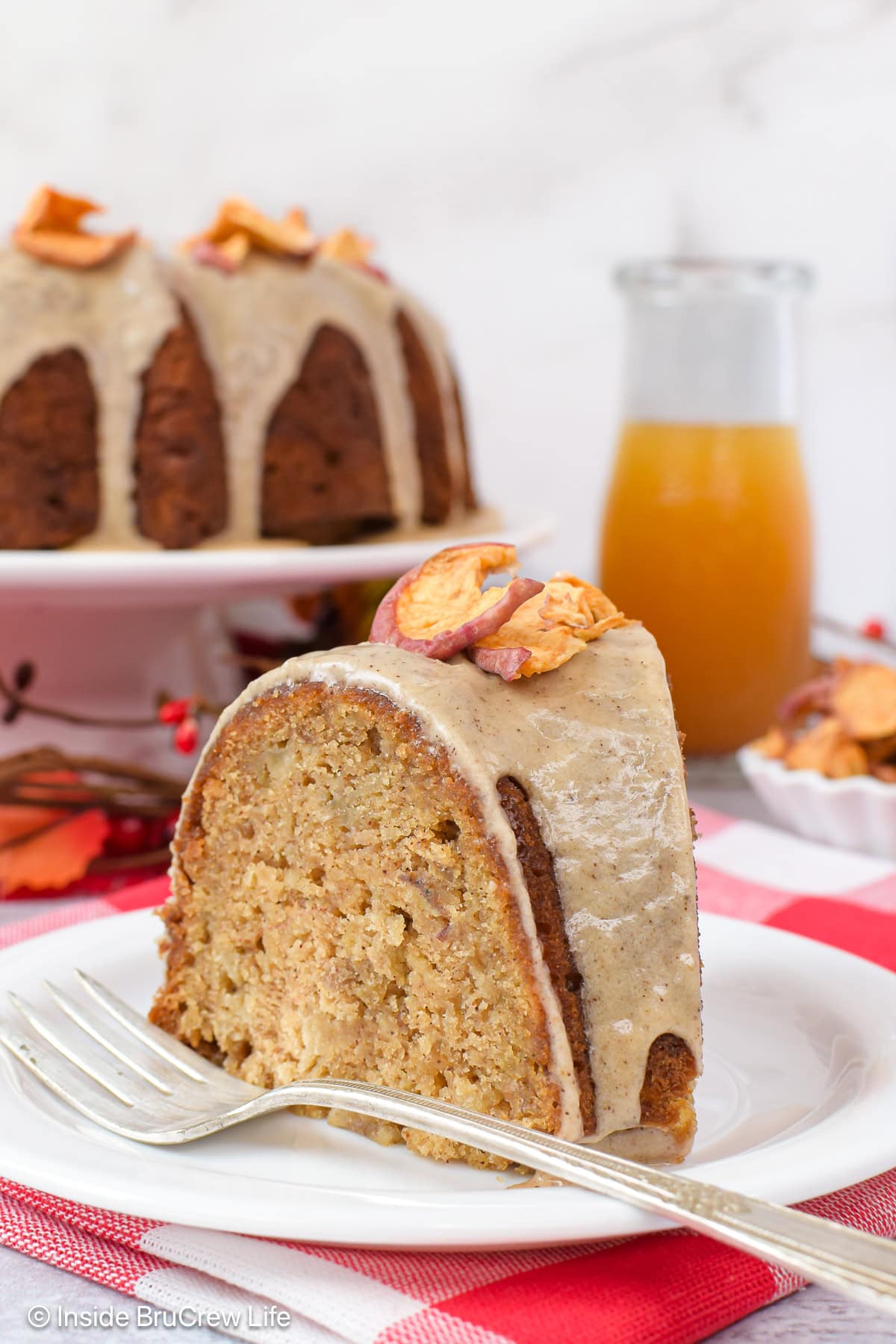 A slice of toffee apple cake with glaze on a white plate.