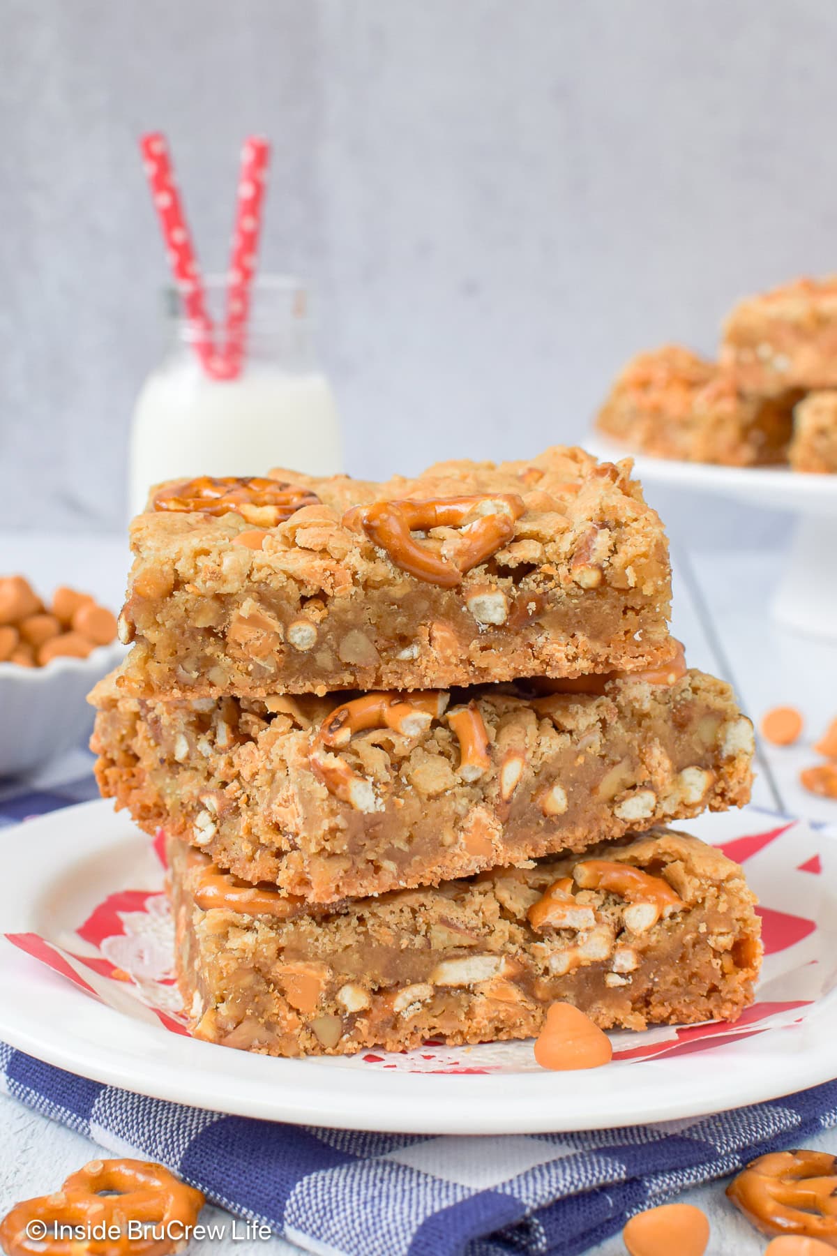 Three squares of pecan blondes stacked on a white plate.