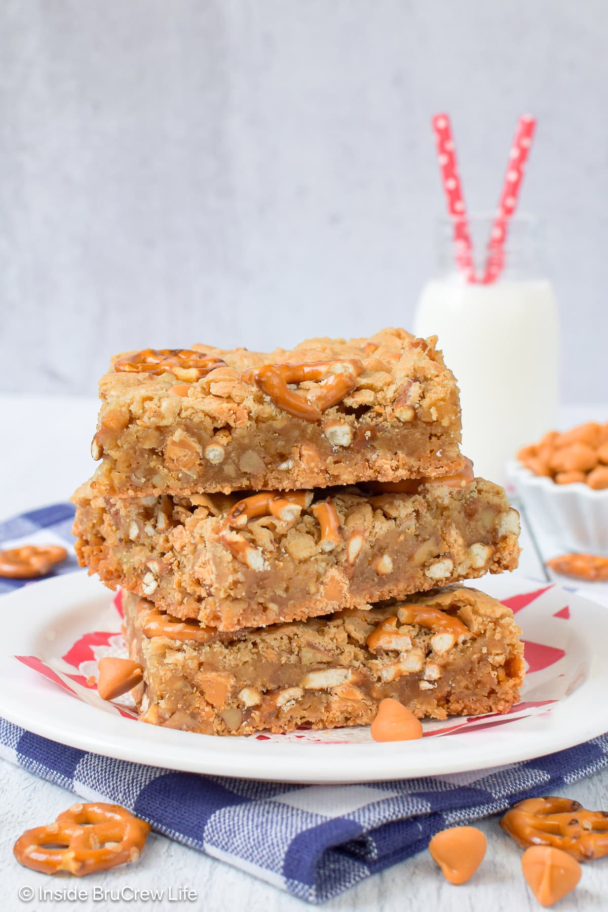 Three butterscotch pecan blonde brownies on a white plate.