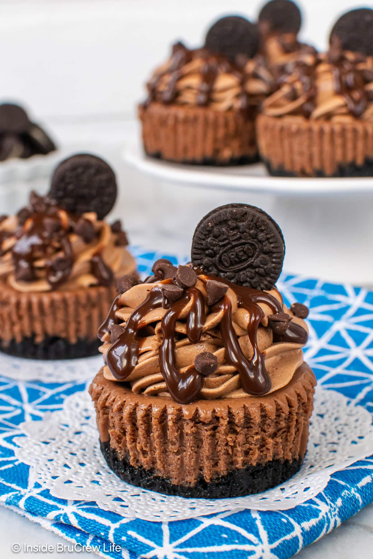 Triple chocolate cheesecakes on a white and blue towel.