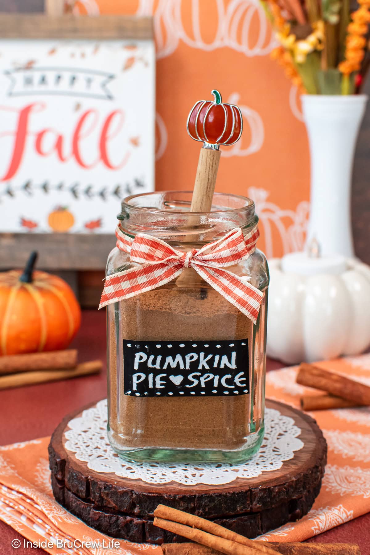 A jar of pumpkin spice with a label and orange bow.