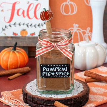 A jar of pumpkin spice with a label and orange bow.