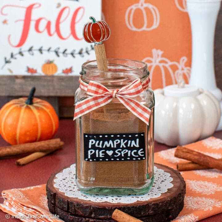 A jar of pumpkin spice with a label and orange bow.