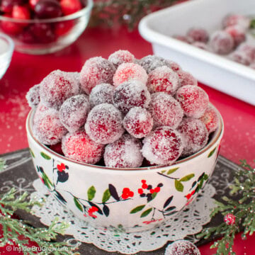 A white bowl filled with frosted cranberries.