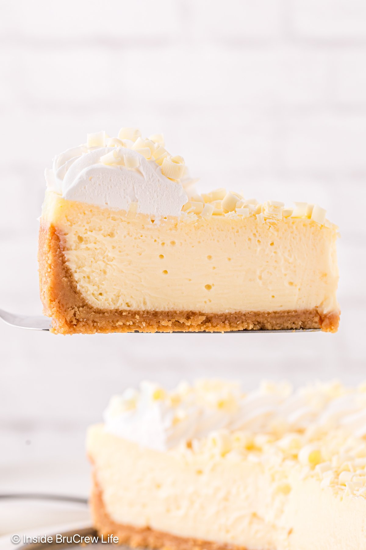 A slice of cheesecake being lift out of a pan with a spatula.