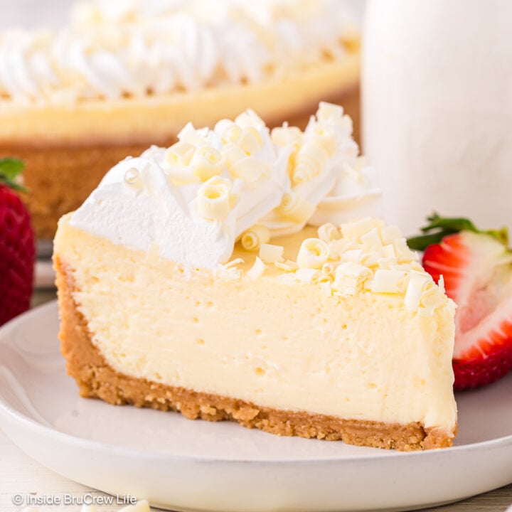 A slice of white chocolate cheesecake on a white plate.