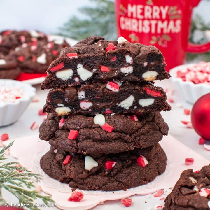 A stack of chocolate peppermint chip cookies with one cut in half.