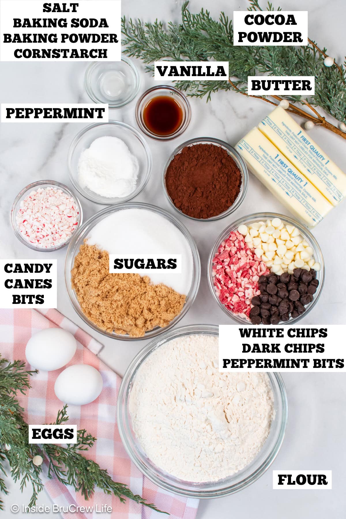 A white board with bowls of ingredients needed to make chocolate and peppermint cookies.