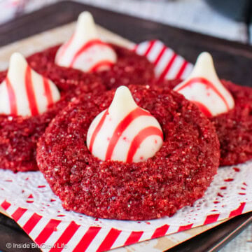 Sparkly red velvet blossom cookies with peppermint kisses on a tray.