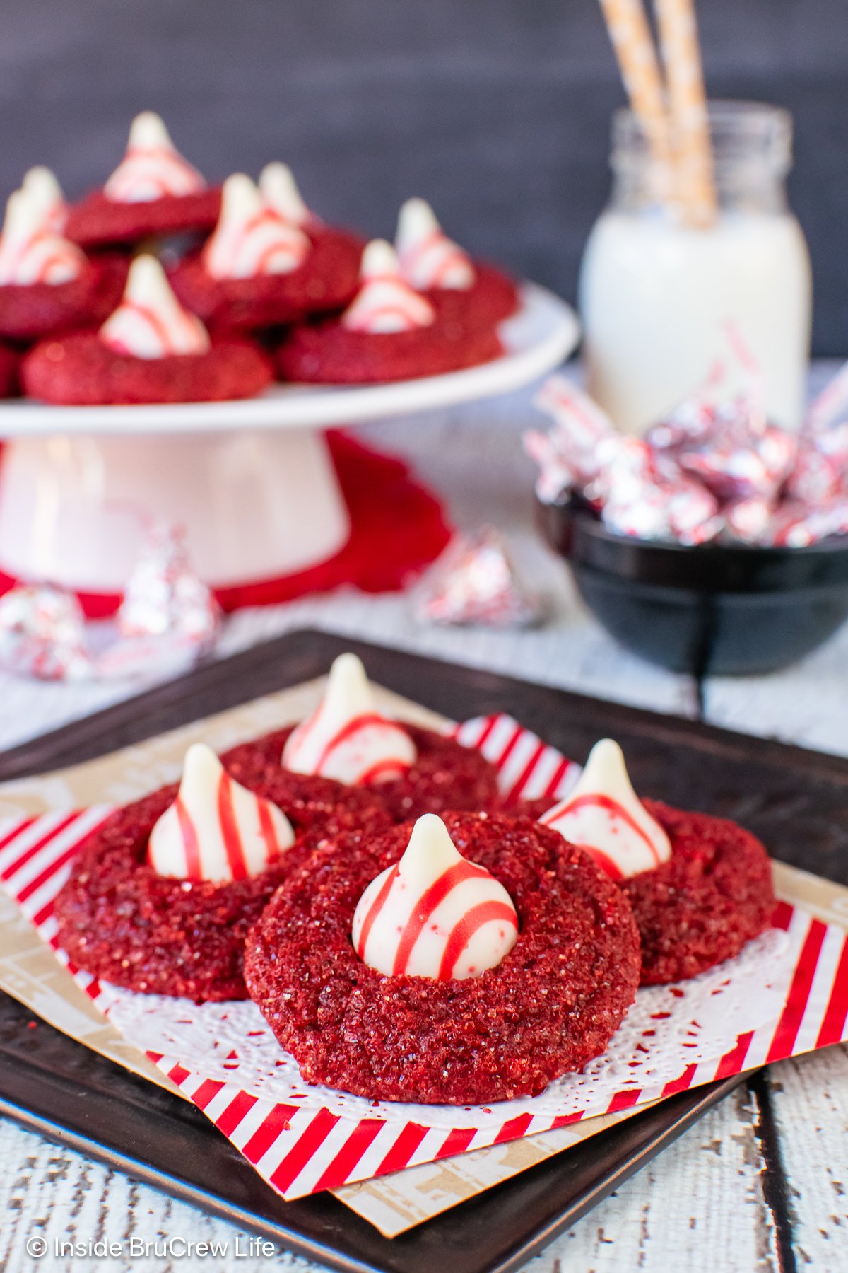 Four red velvet kiss cookies on a white paper.