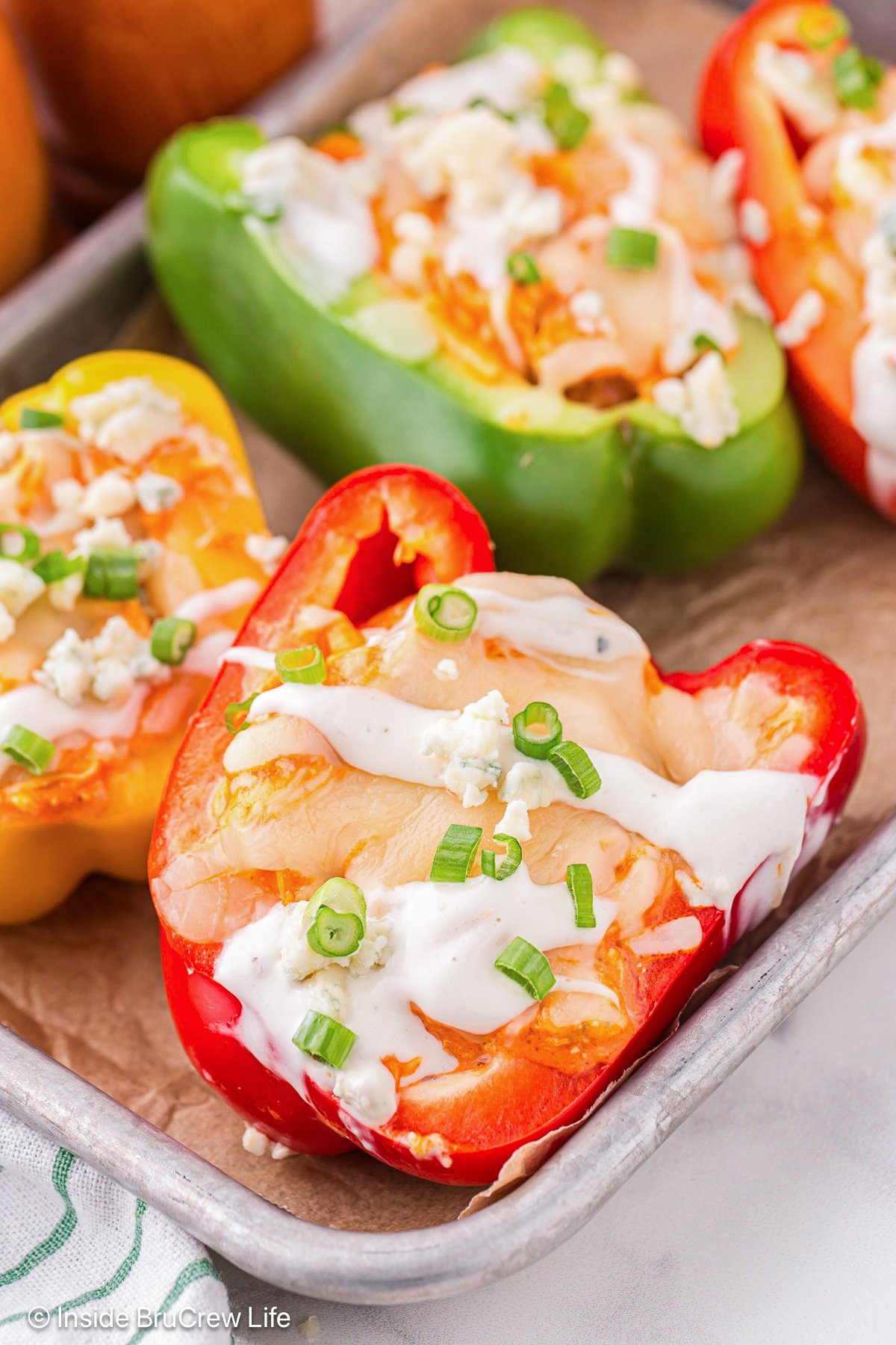 A metal tray filled with buffalo chicken stuffed bell peppers.