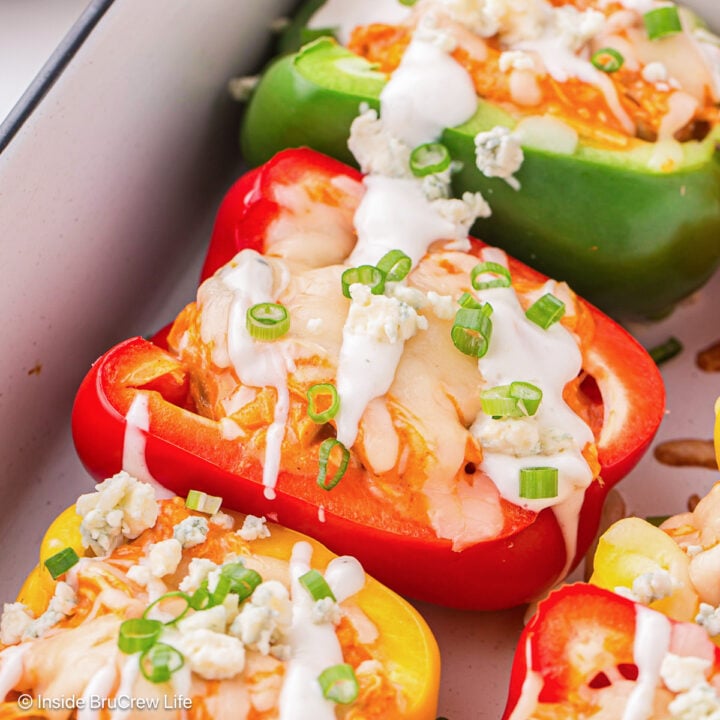 Stuffed chicken peppers topped with dressing and green onions.