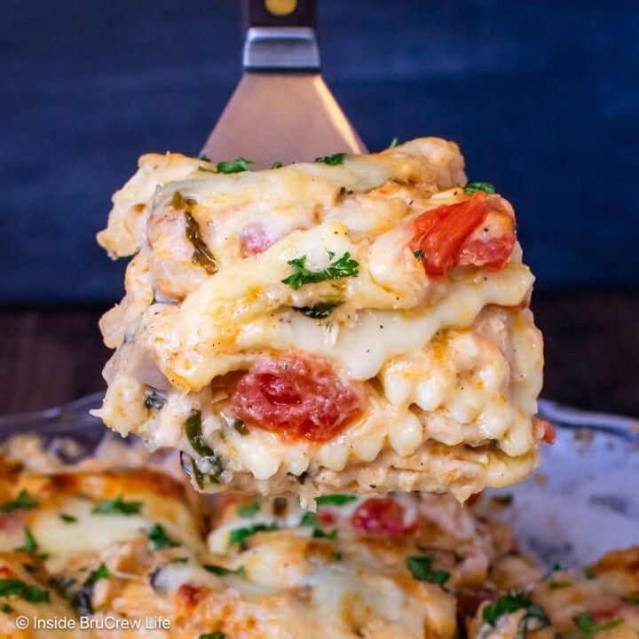 A square of cheesy pasta being lifted out of a casserole dish.