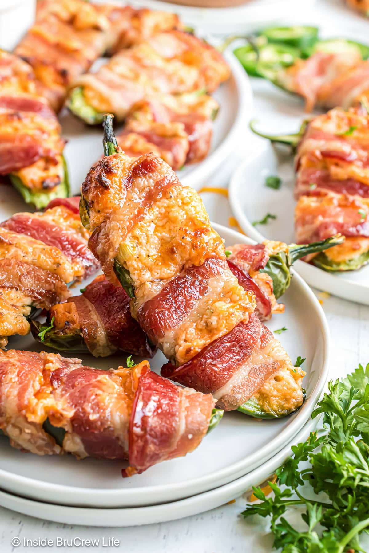 A close up of bacon wrapped jalapeno poppers cooked in an air fryer.