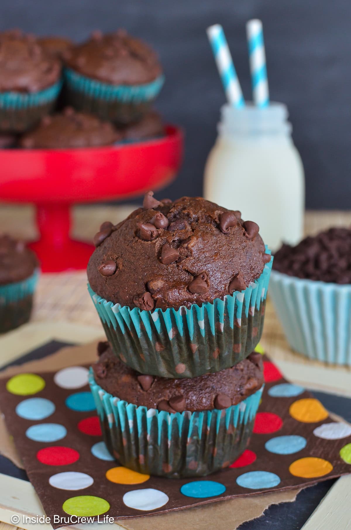 Two chocolate chocolate chip banana muffins stacked on top of each other.