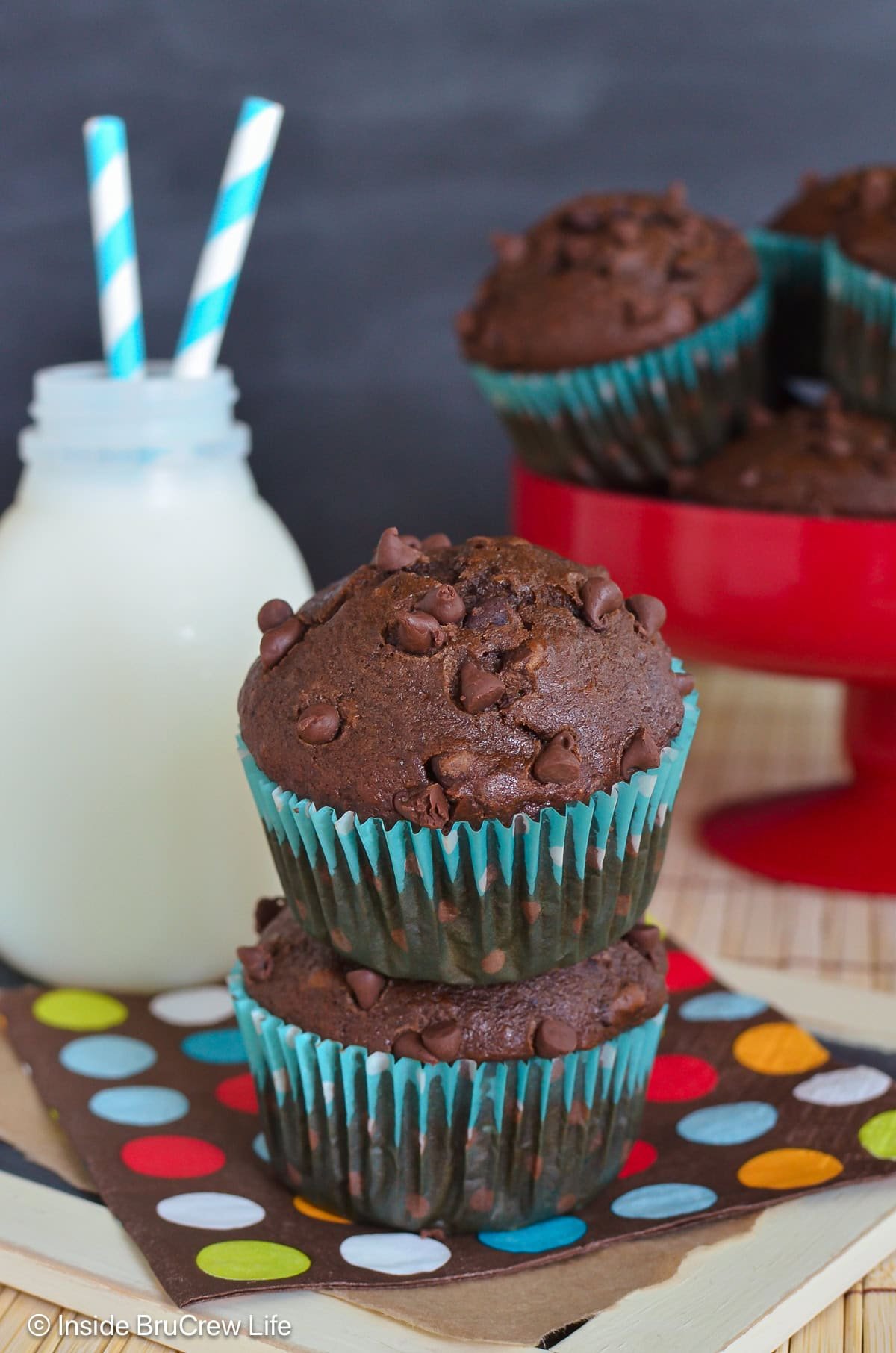 Two chocolate muffins stacked on top of each other.