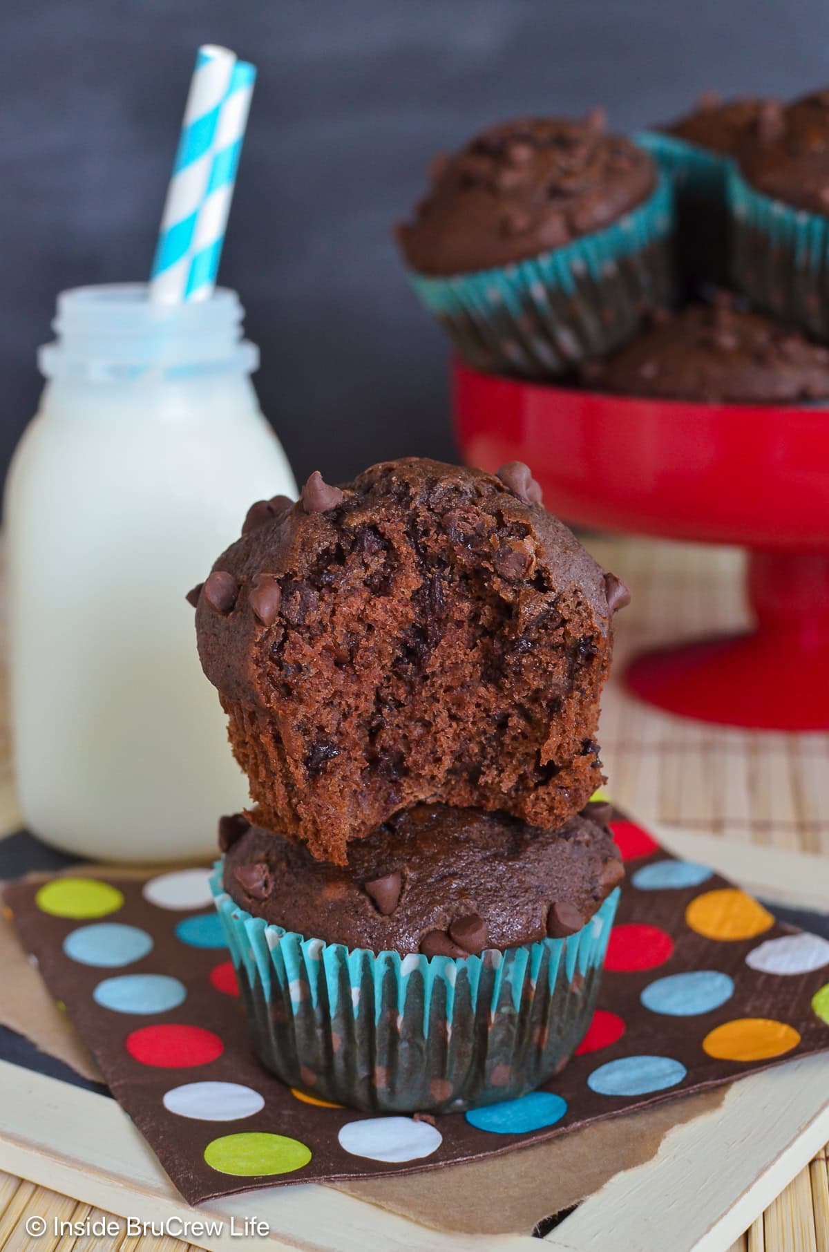 Half a chocolate chocolate chip muffin sitting on another muffin.