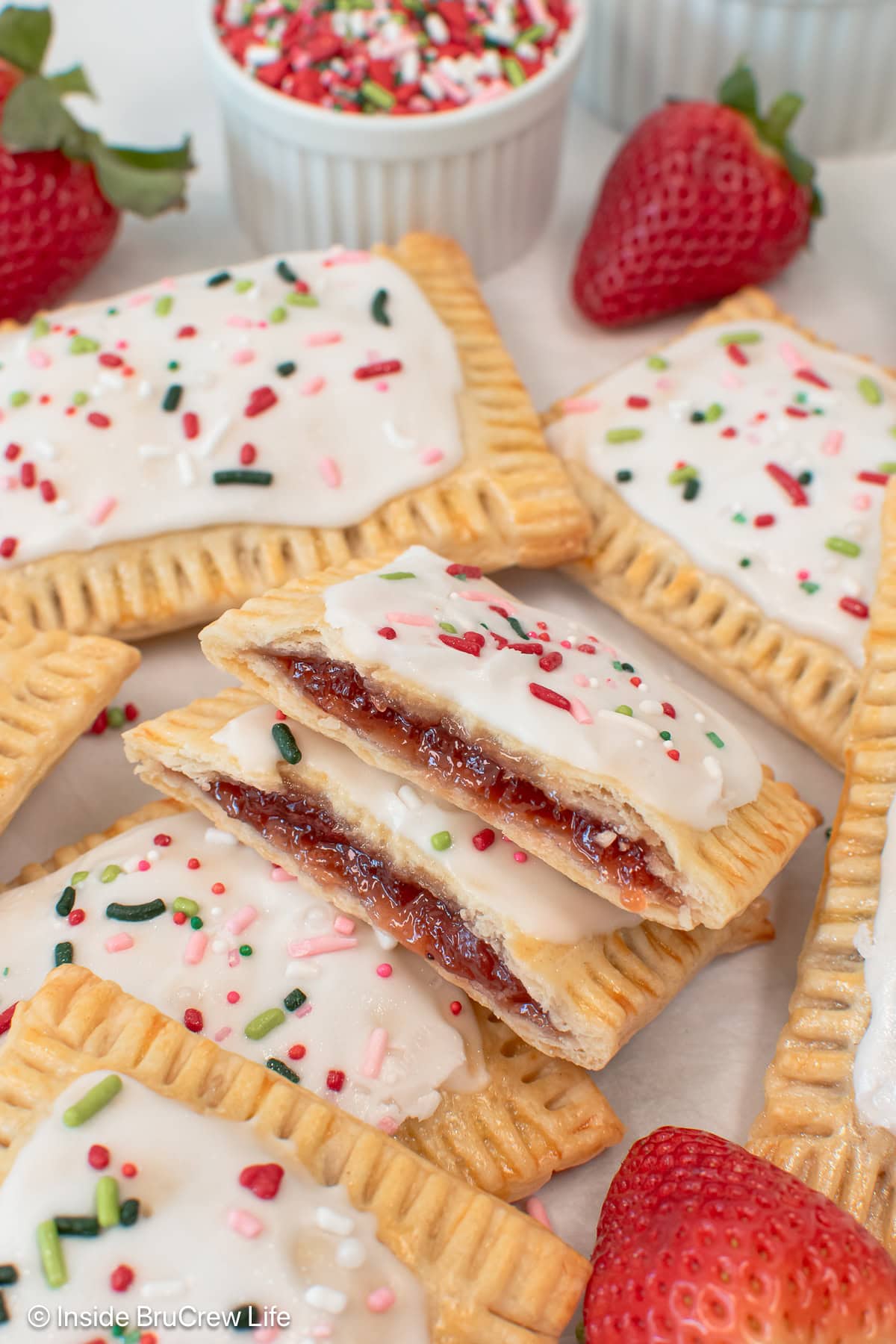 Homemade pop tarts filled with strawberry preserves in a pile.