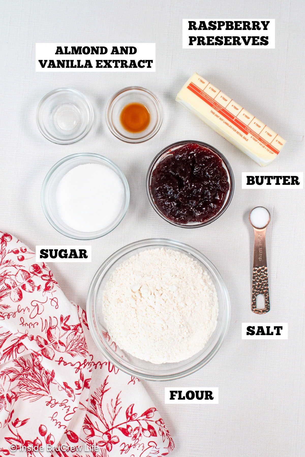 Bowls of ingredients needed to make crumble cookies with raspberry preserves.