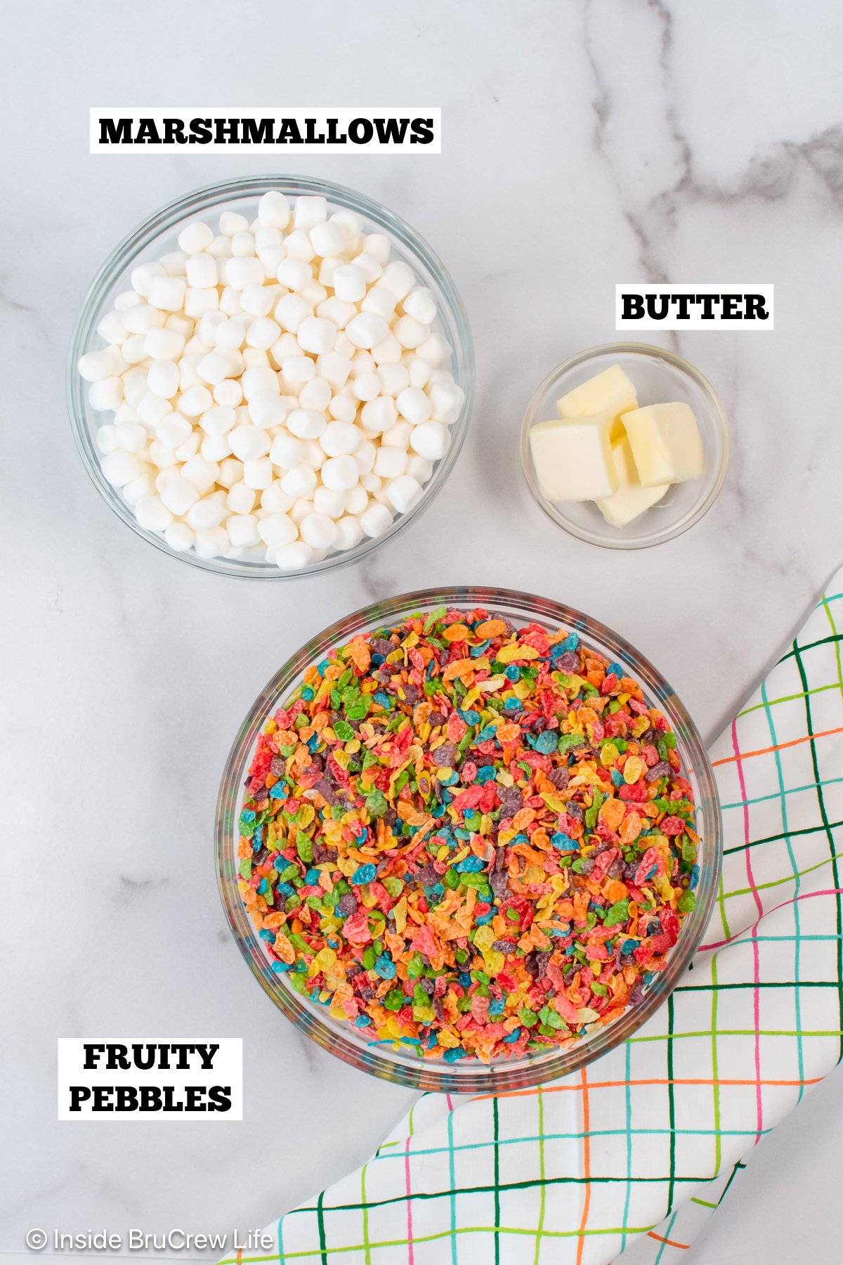 Bowls of ingredients needed to make fruity pebbles treats.