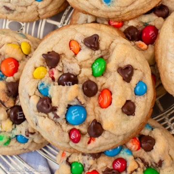 Chocolate chip cookies with M&M candies on a cooling rack.