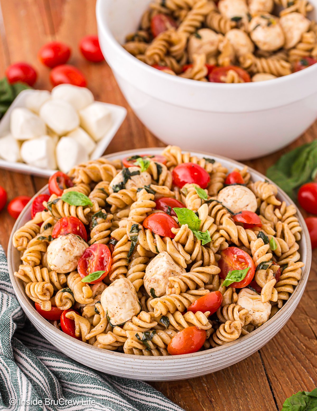 A bowl of Caprese salad with noodles.