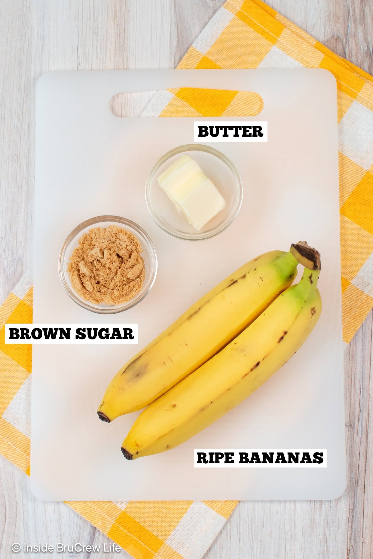 Ingredients needed to make caramelized bananas on a white cutting board.