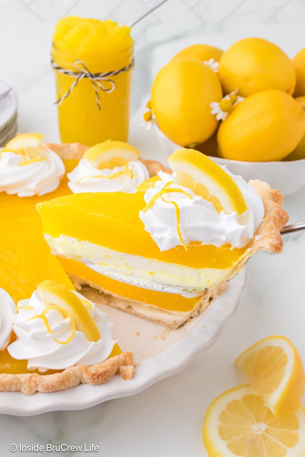 A slice of lemon pie being lifted out of a pie plate.